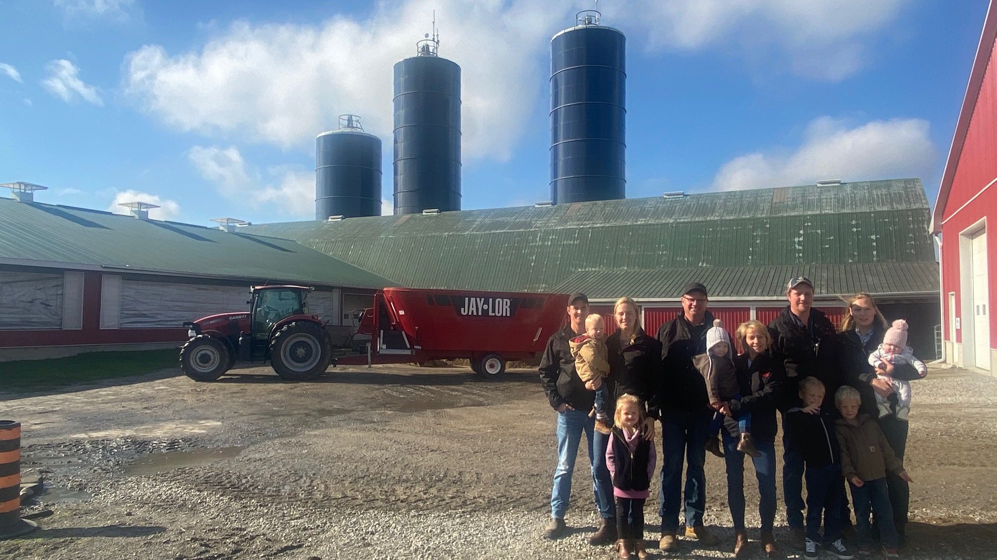 The VanDerMolen family outside of their barn with a 5850 Jaylor TMR mixer