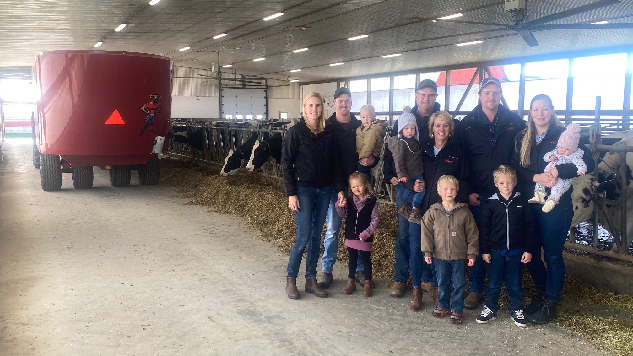 The VanDerMolen family standing infront of their cattle feedback with a Jaylor TMR mixer