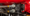 Close-up of hydraulic hoses connected to a black valve block inside a red industrial machine; one hose is labeled 'Made in Italy'