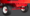 Close-up of a red industrial cart's undercarriage showing two large off-road tires with white rims and a red axle.