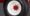 Close-up of a white steel wheel with a red center cap and red lug nuts, mounted on a black tire (BKT) with visible tread.